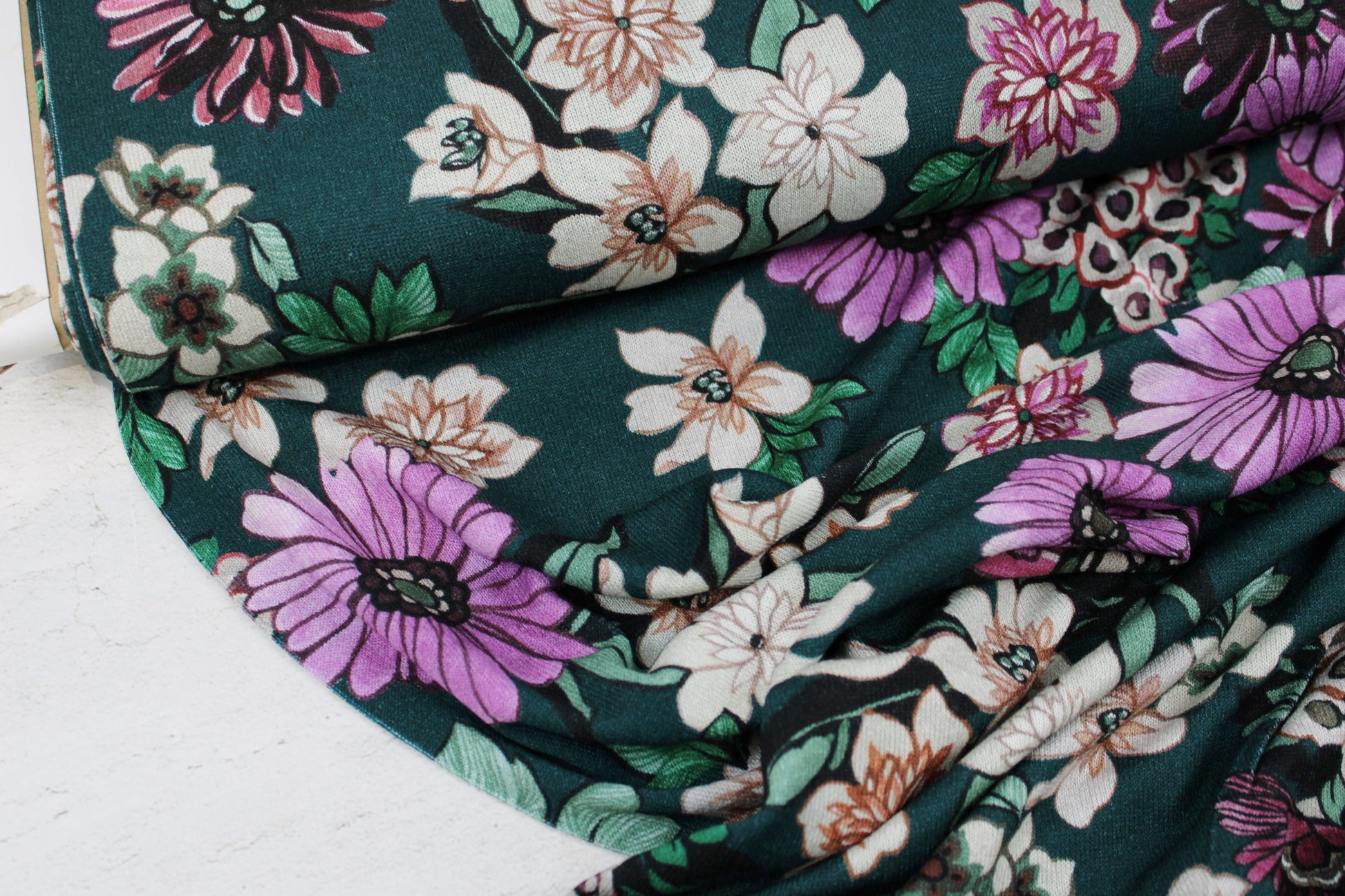 Viskosestrick Casablanca mit buntem Blumenprint auf Petrol farbenem Grund Ballenasicht