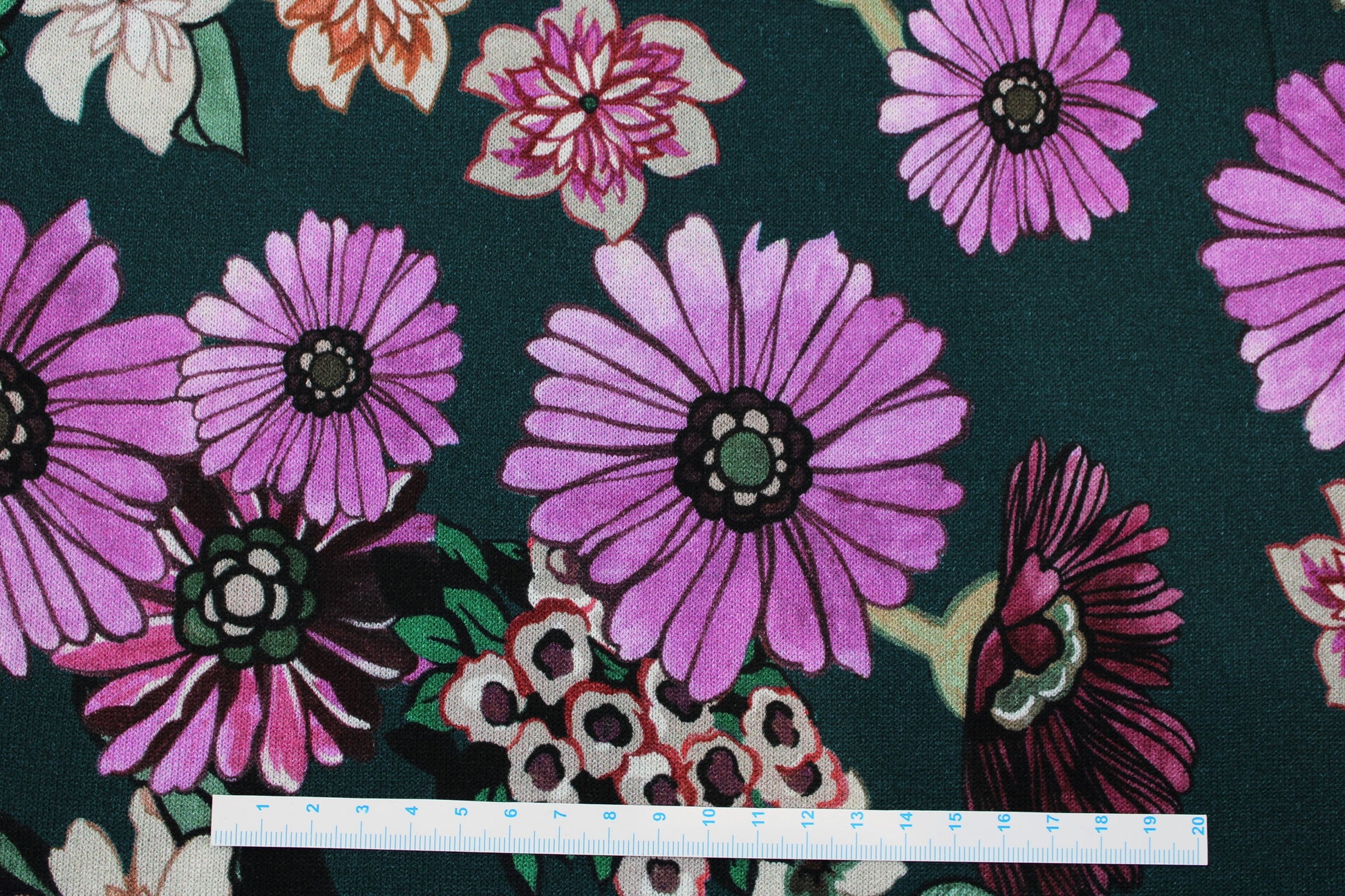 Viskosestrick Casablanca mit buntem Blumenprint auf Petrol farbenem Grund Maßstab